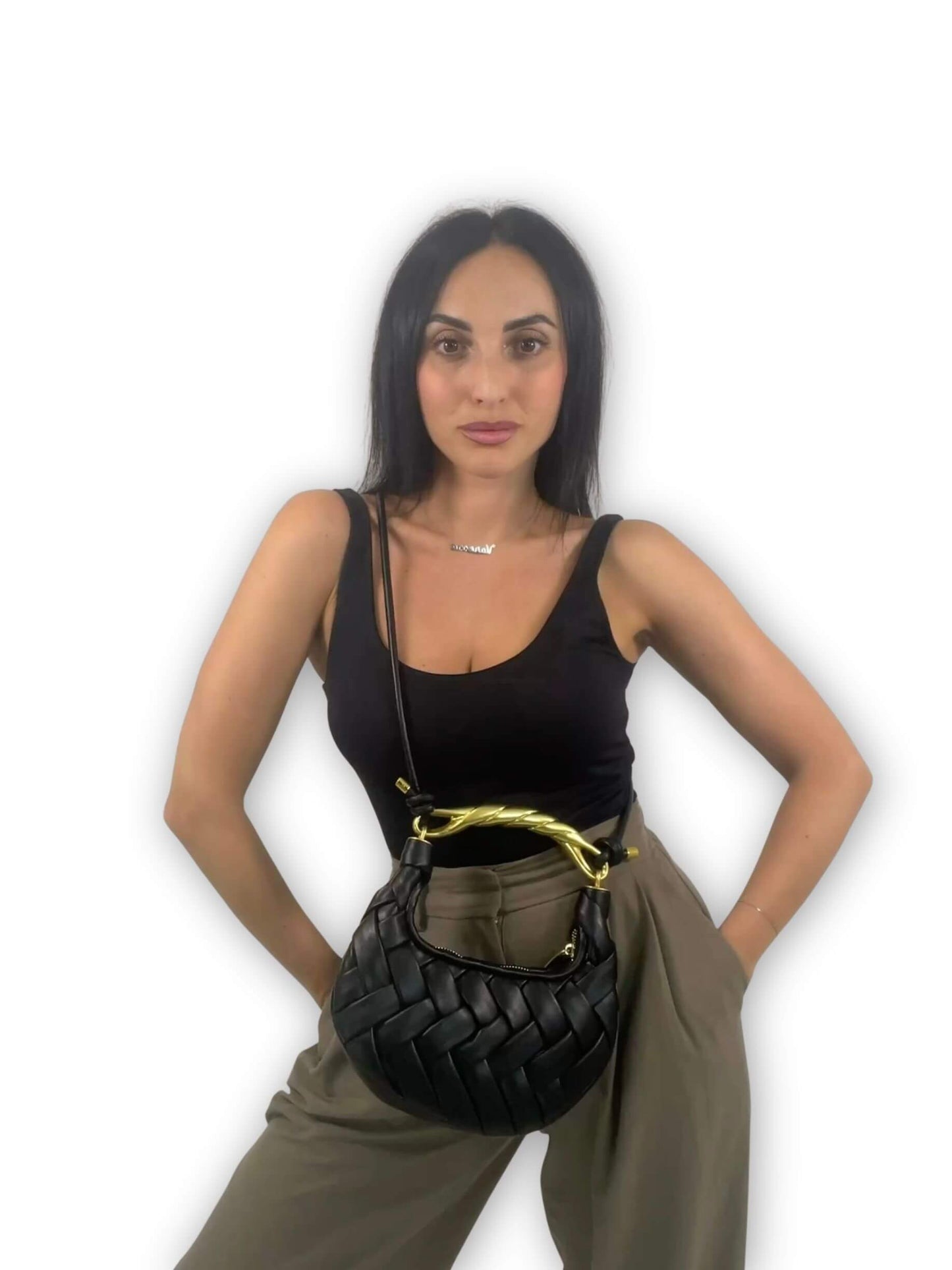 Look con borsa Daphne ÈCLAT nera indossata crossbody, intrecciata a mano con manico twist dorato ispirato a JW PEI