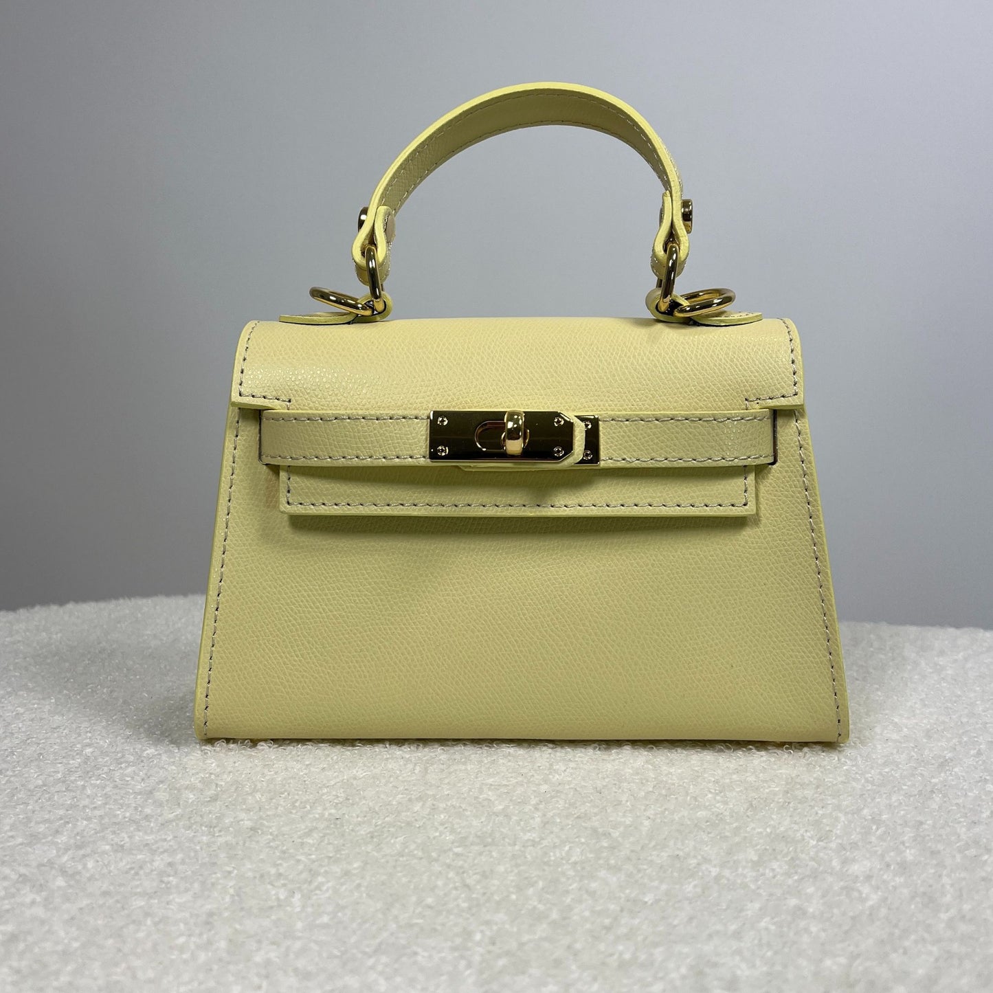 Borsa Minikate gialla vista frontale, pelle martellata con chiusura dorata, stile Mini Kelly Hermès