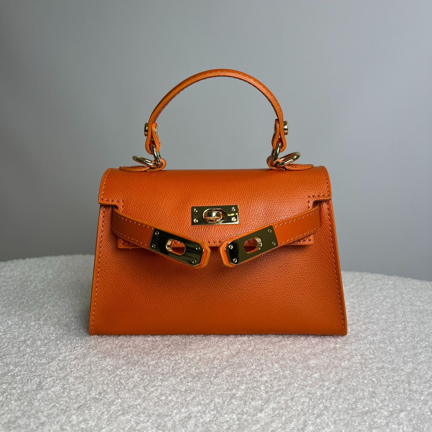 Borsa Minikate arancione papaya in pelle martellata vista dall’alto, ispirazione Mini Kelly Hermès