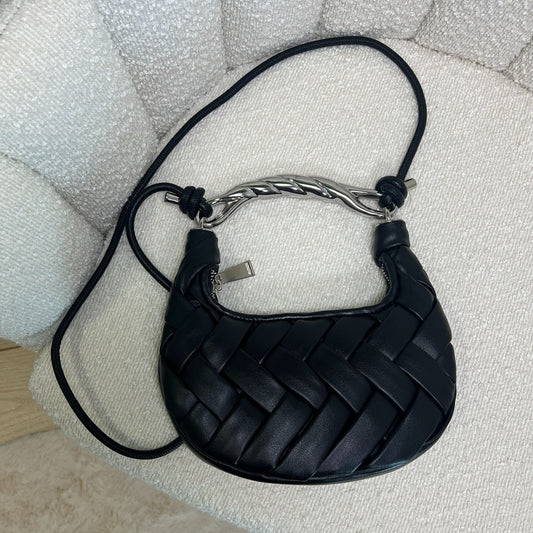 Dettaglio superiore della borsa nera in pelle con intreccio artigianale e manico argento twist