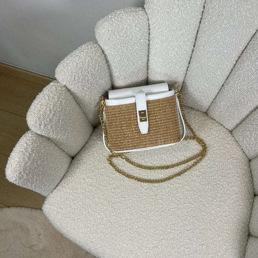 Borsa ÈCLAT Alma in rafia e pelle color bianco, con catena dorata, fotografata dall’alto