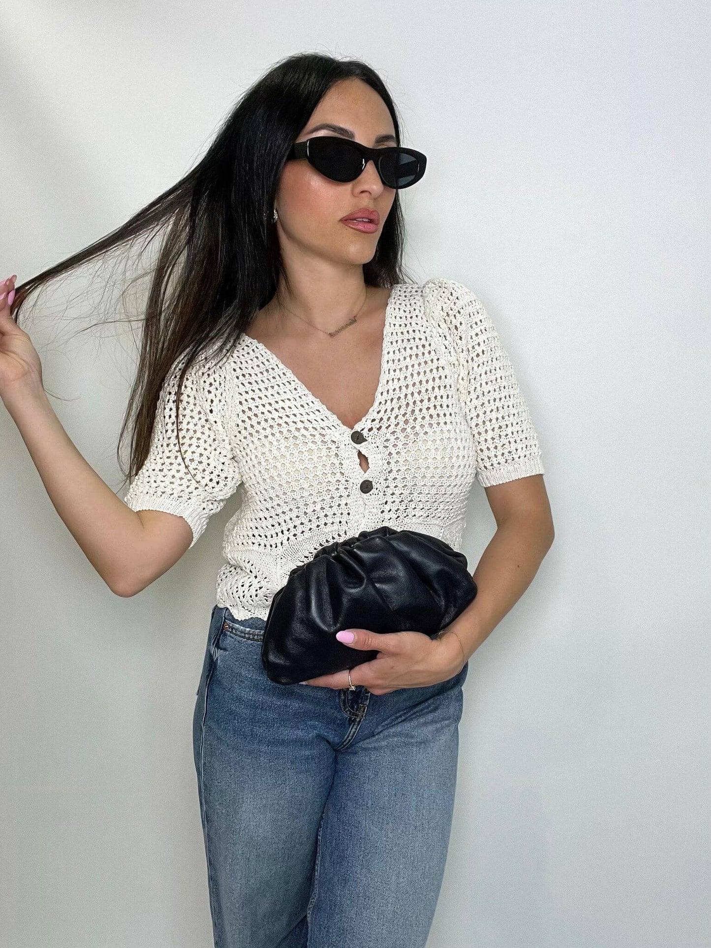 Modella che indossa mini pouch nera ÉCLAT Bags in stile Bottega Veneta, look elegante e raffinato