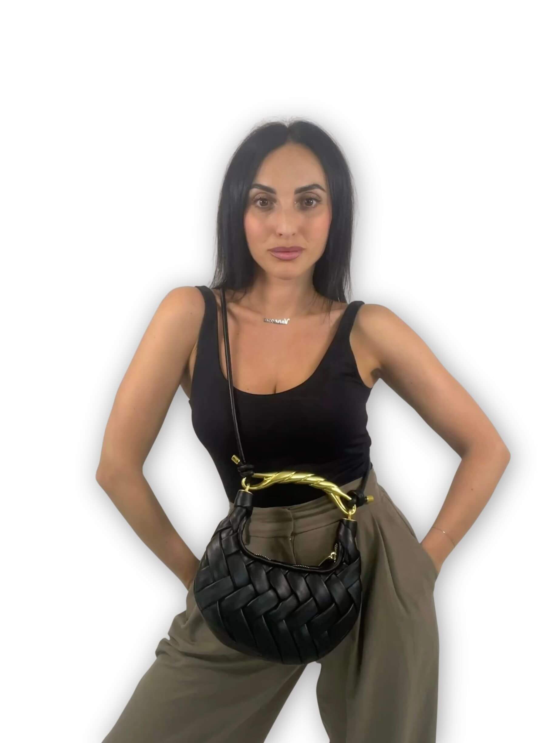 Look con borsa Daphne ÈCLAT nera indossata crossbody, intrecciata a mano con manico twist dorato ispirato a JW PEI